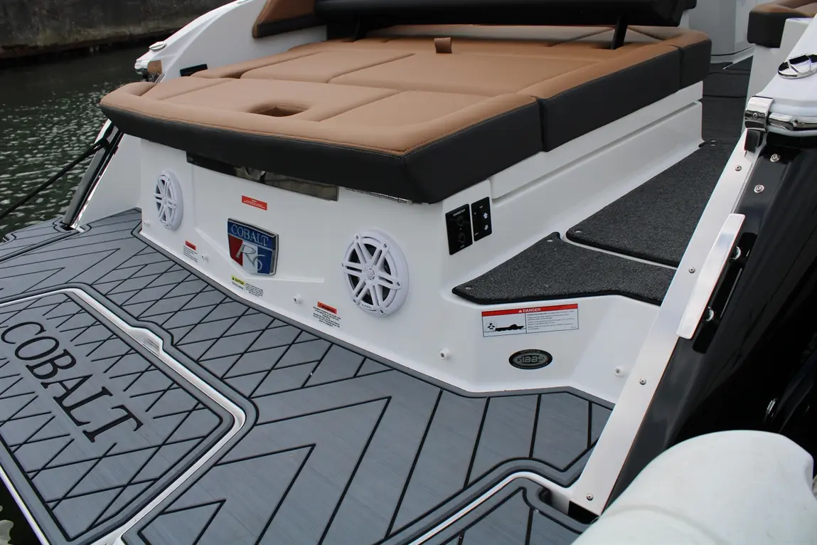 Cobalt R5 boat interior showcasing tan seating, audio speakers, and grey Anti-Slip surface with Cobalt branding.